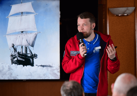 Ein Referent hält an Bord des Kreuzfahrtschiffs einen Vortrag über die frühen Polarforscher der Arktis